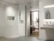Moderne Dusche mit klaren Linien, ausgestattet mit einer Handbrause und einem Wandhalter. Ideal Standard Waschtischarmatur im Hintergrund, schlicht und funktional.